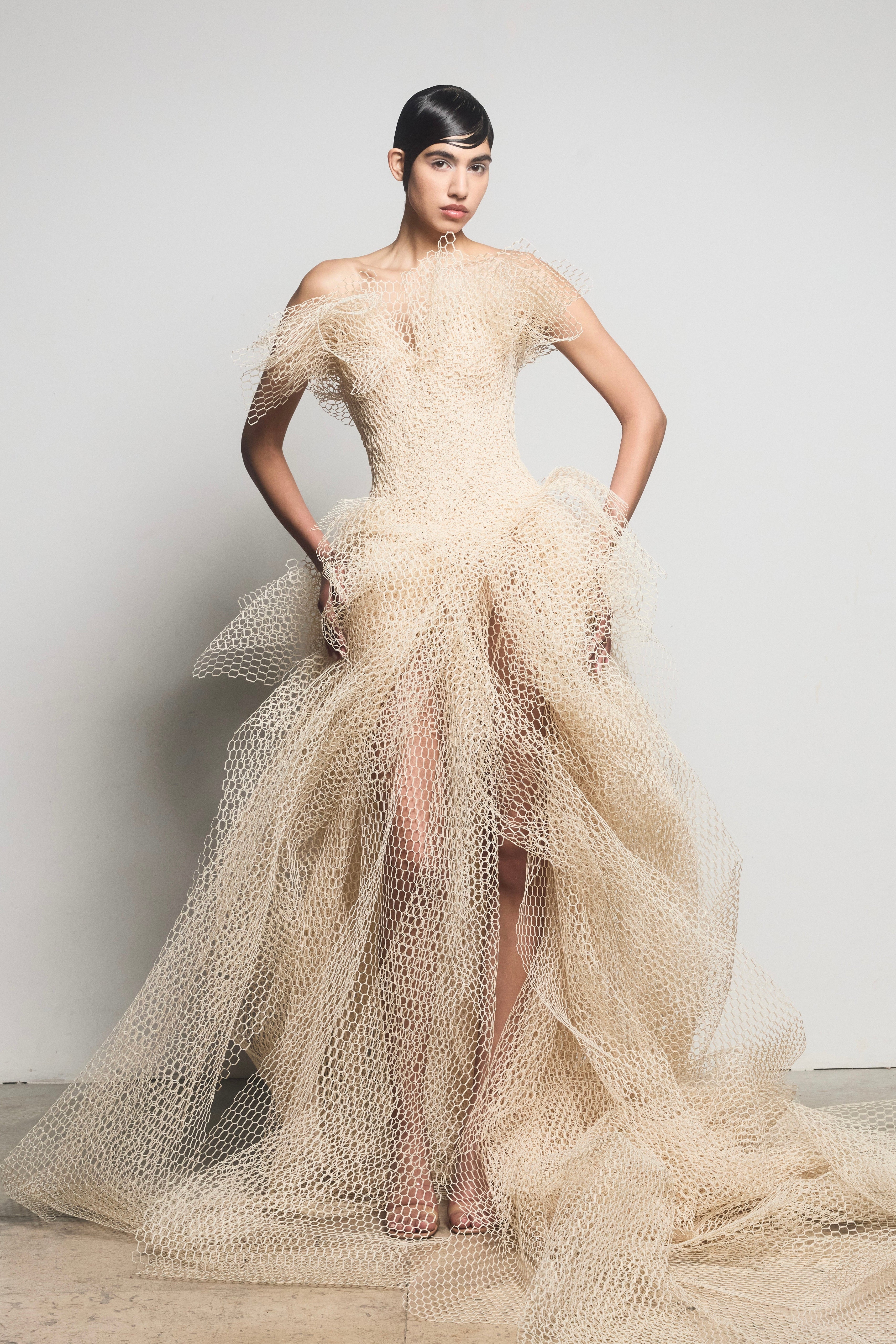 Model in off-shoulder beige gown crafted from sculpted straw-effect material